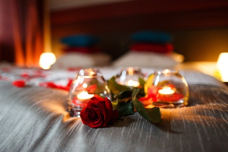 Chambre romantique avec roses et bougies sur lit
