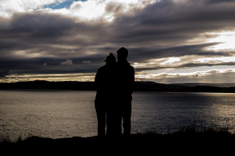 silhouette d'un couple s'étreignant devant le lac