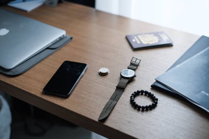 smartphone noir et montre-bracelet marron