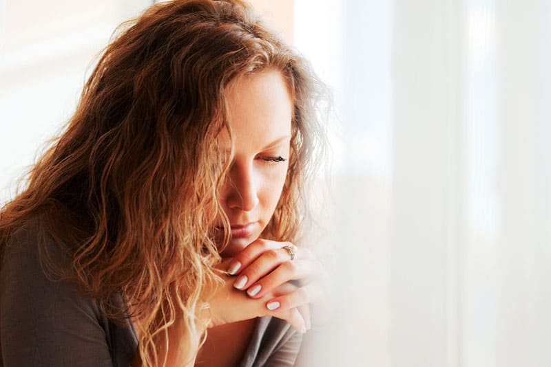 triste brune aux cheveux bouclés à la maison