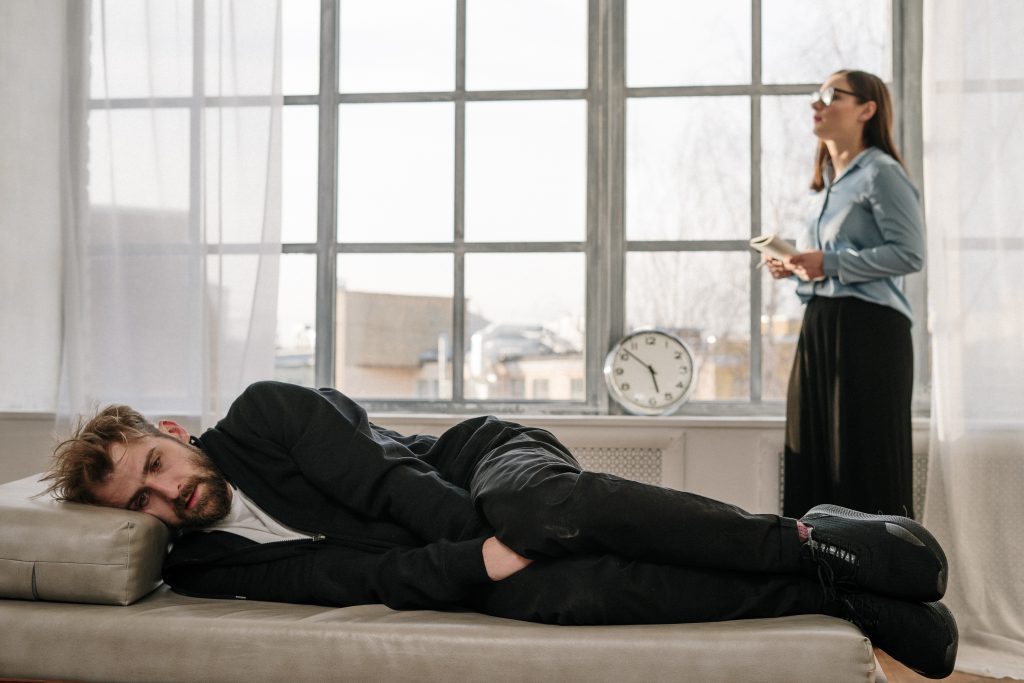 un homme couché femme regardant par la fenêtre