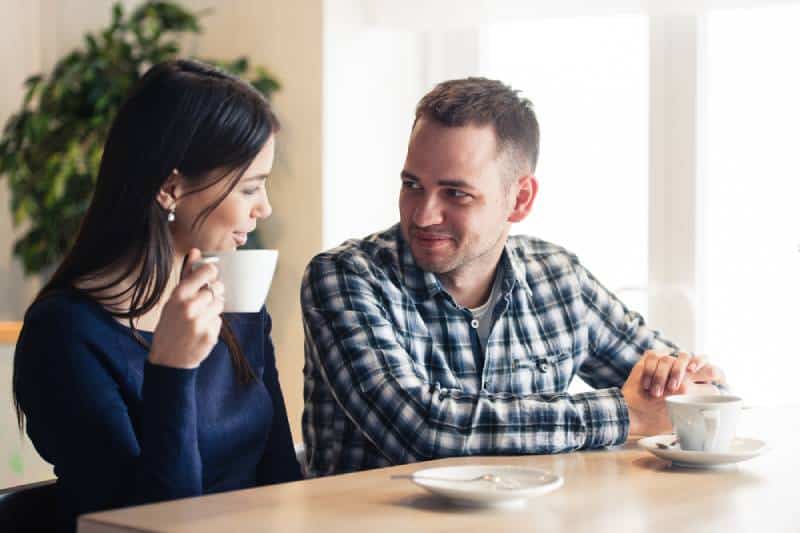 un homme et une femme discutant au café et buvant du thé