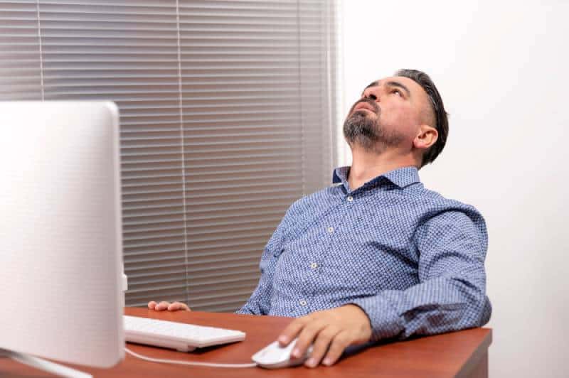 un homme mûr malheureux qui s'ennuie et qui utilise un ordinateur