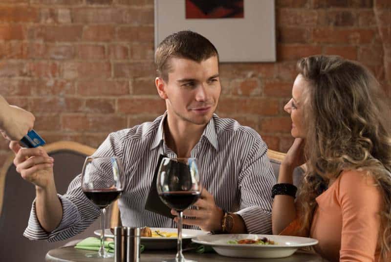 un homme qui paie son dîner le jour du rendez-vous