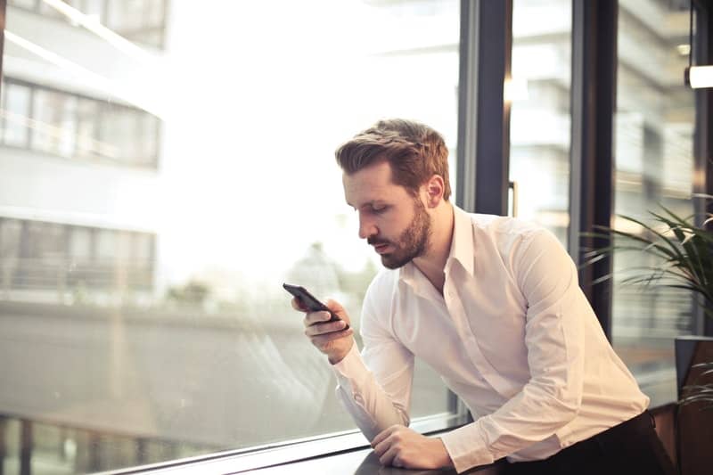 un homme qui tape sur son téléphone