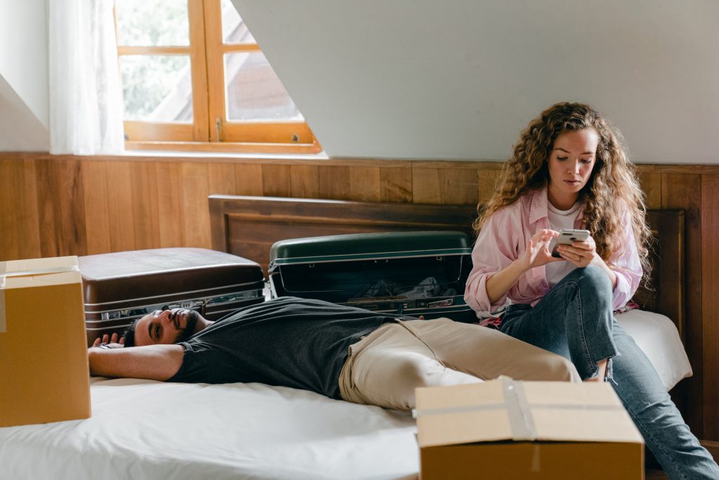 un homme se trouve sur un lit une femme est assise et une clé sur un téléphone portable