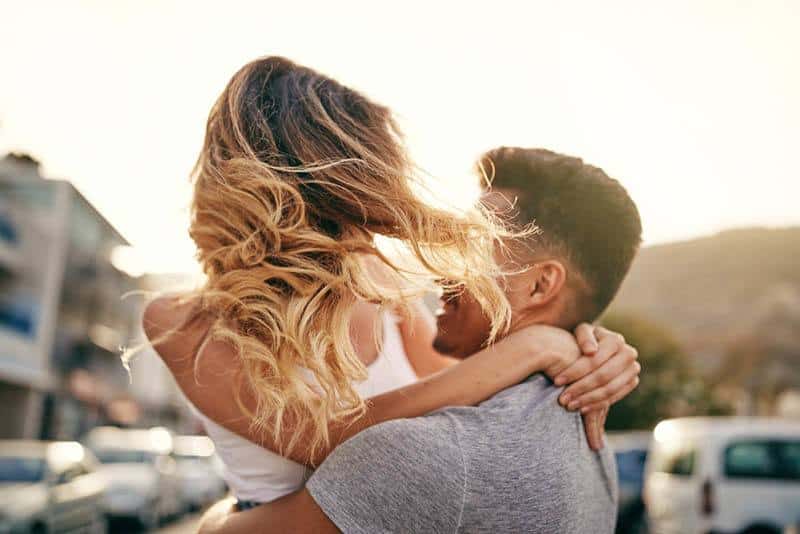 un homme étreint une femme autour de sa taille à l'extérieur