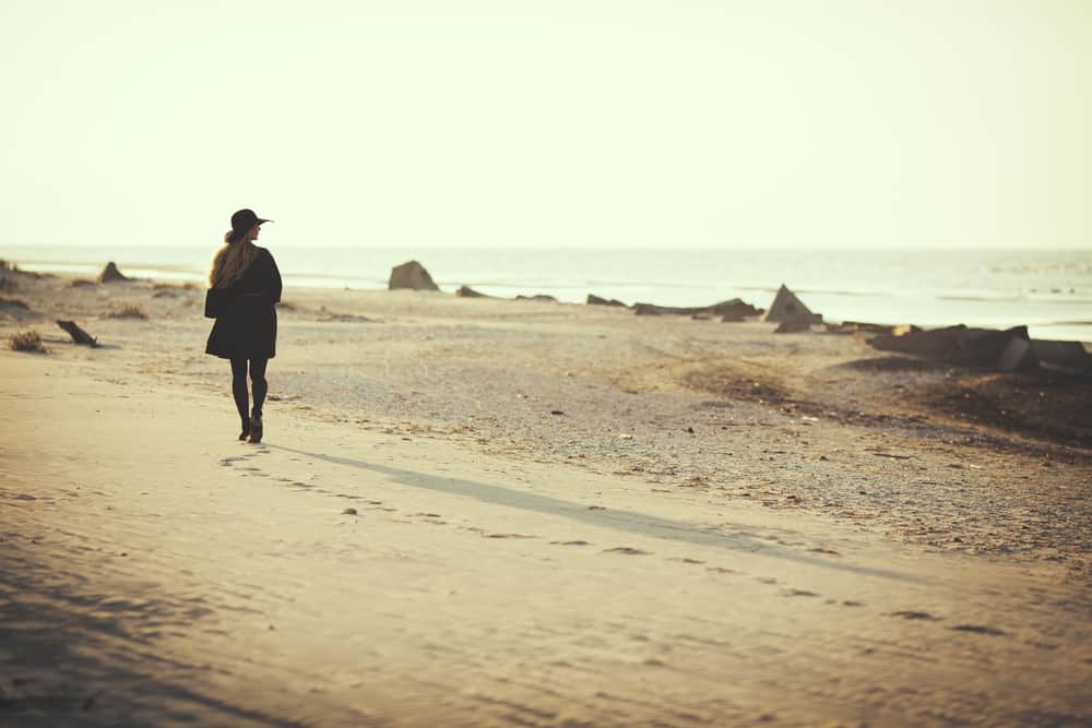 une femme debout près de la plage