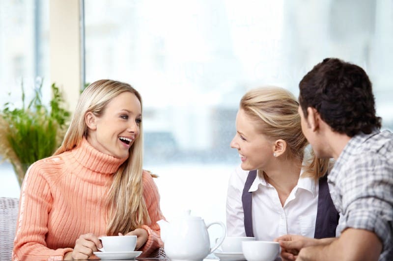 une femme heureuse parle à un homme et une femme