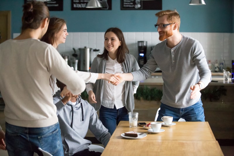 une femme se présentant avec un groupe d'amis dans un café