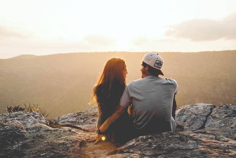 vue arrière d'un couple assis sur une colline