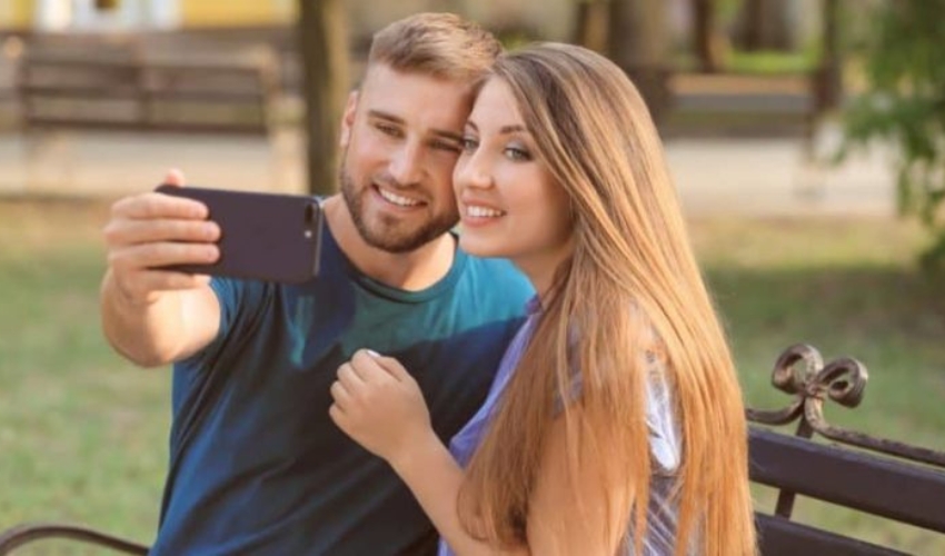 un homme et une femme prennent des photos