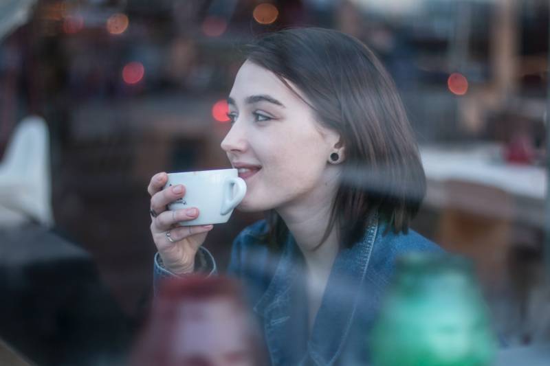 Femme tenant une tasse à thé en céramique blanche