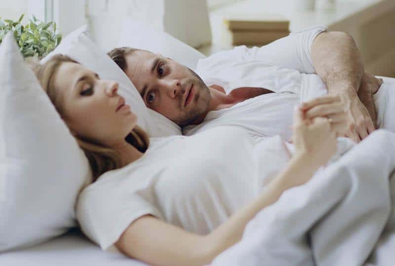 Un couple attentionné allongé sur le lit