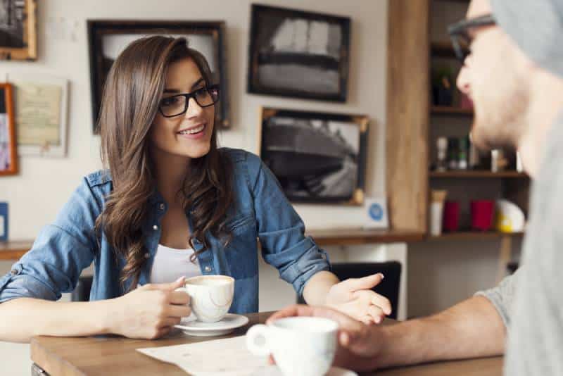 Un couple de hipsters parle dans un café
