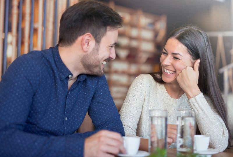 Un couple souriant s'amuse dans un café