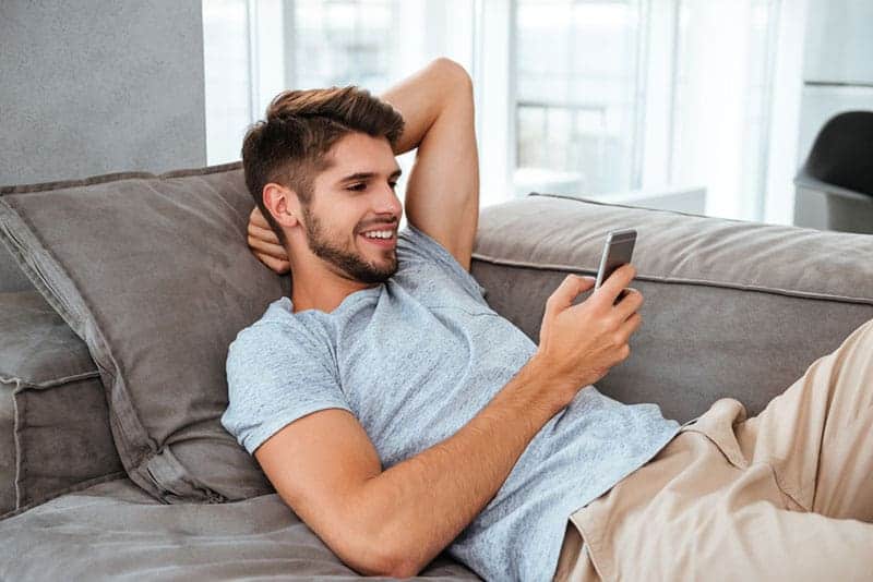 Un homme heureux regarde son téléphone portable
