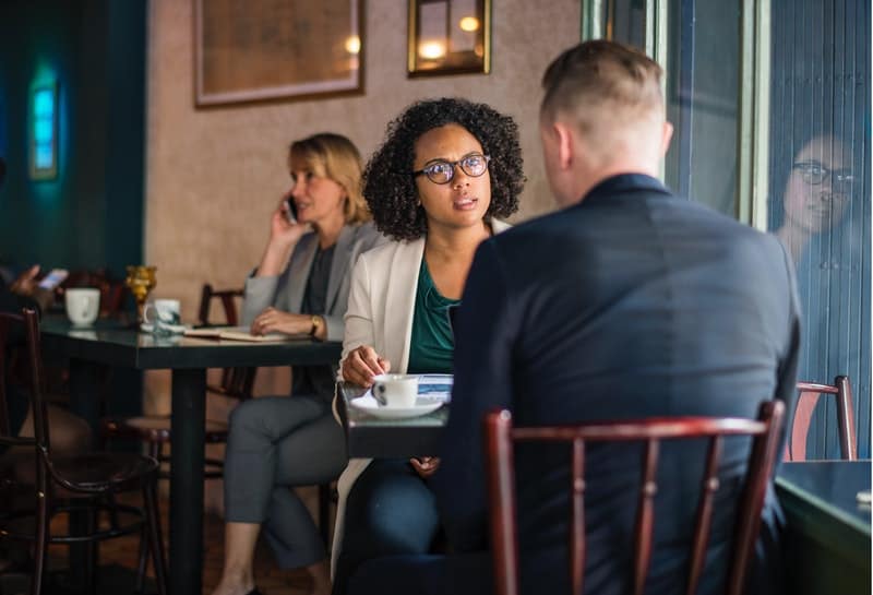 Une femme sérieuse parle à un homme dans un café
