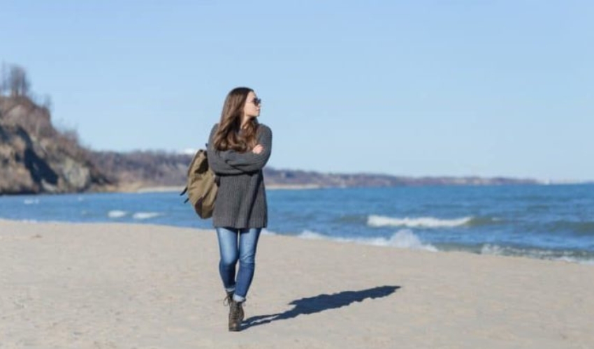 une femme avec des lunettes fixe la plage