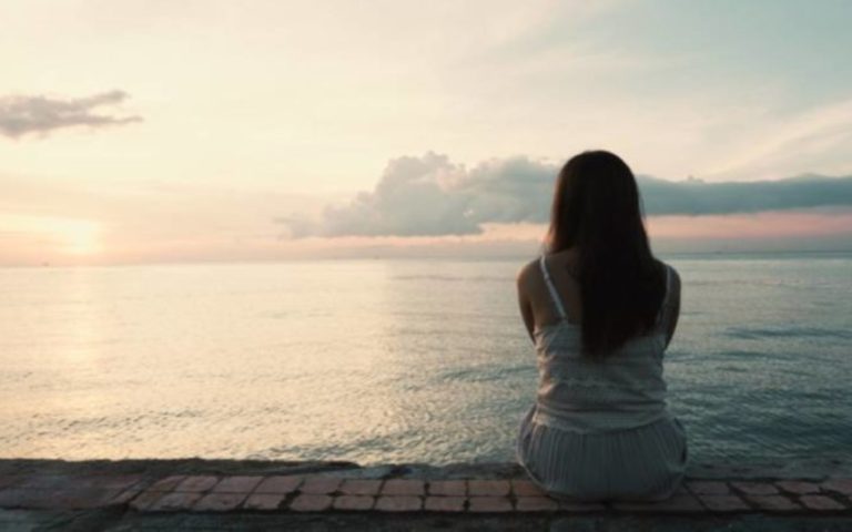 jeune femme assise seule a larriere, a lexterieur, sur la plage dune ile tropicale