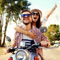 un homme et une femme conduisent une moto