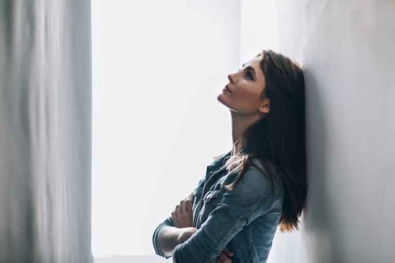 la femme appuyée contre le mur pense