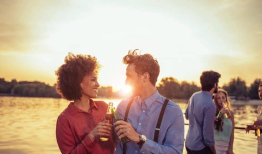 un homme et une femme toast avec de la biere