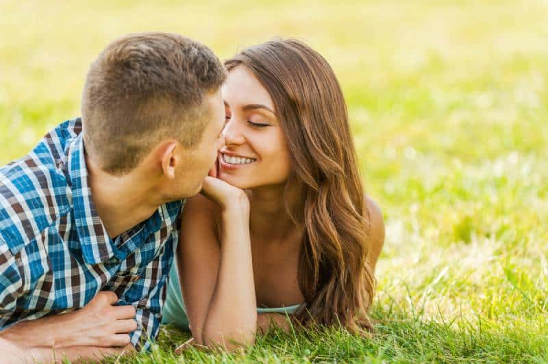 couple allongé sur l'herbe en se regardant