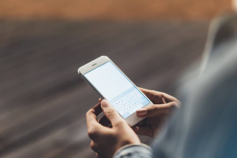 femme tenant son téléphone