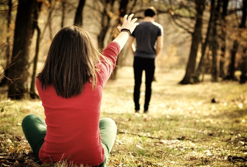 un jeune couple se séparant dans la forêt
