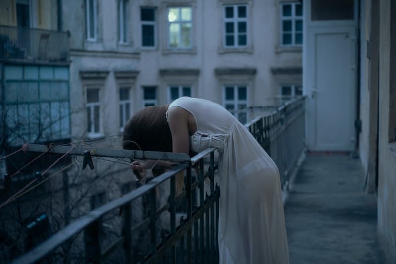 la femme pleure appuyée contre la clôture