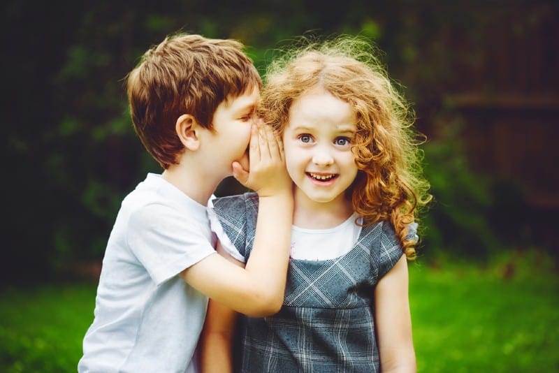 petit garçon chuchotant à lannée des petites filles