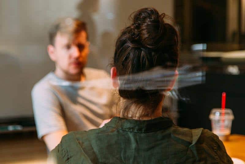 photo à faible profondeur de champ d'un homme et d'une femme discutant dans un café