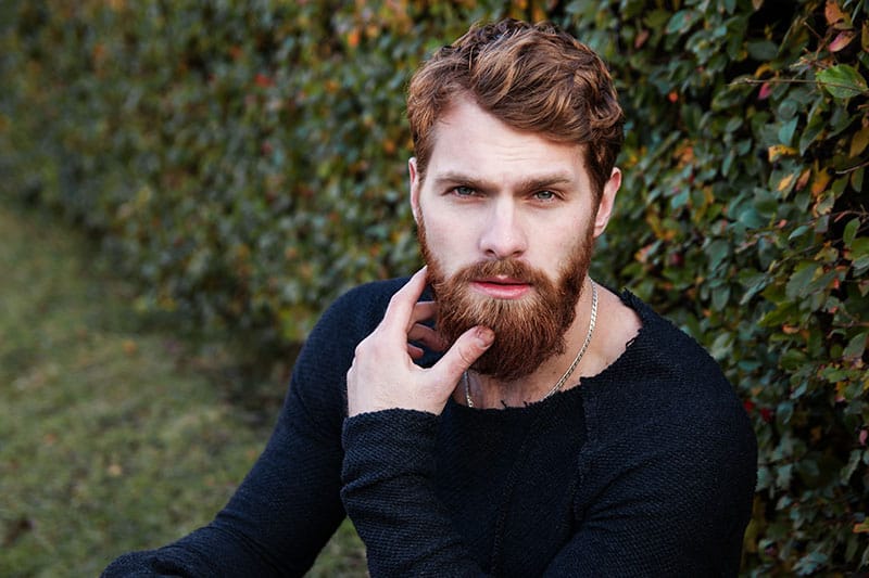 portrait d'un homme barbu se tenant à l'extérieur