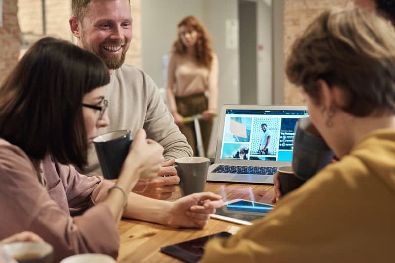 un homme assis avec des amis une femme entre dans un café