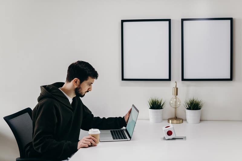 un homme assis à un bouton de bureau sur un ordinateur portable