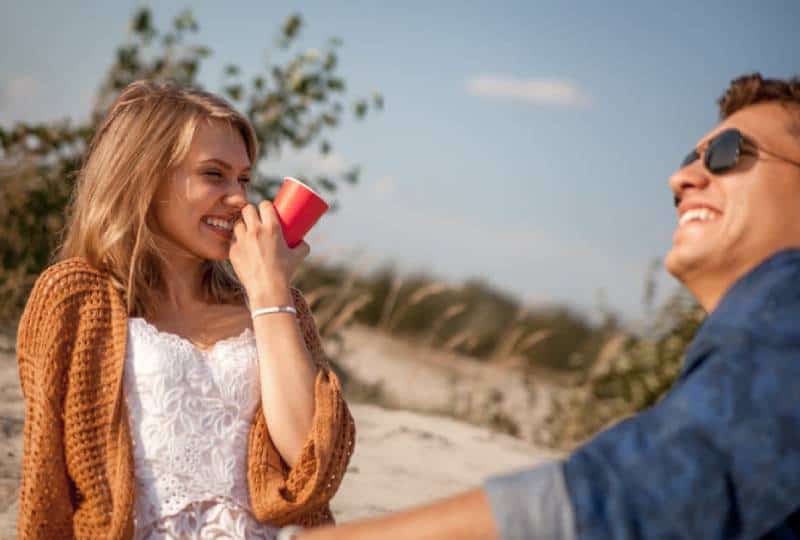 un homme et une femme riant et buvant du café