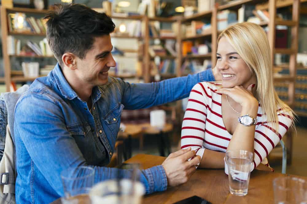 un homme et une femme s'assoient à une table et rient