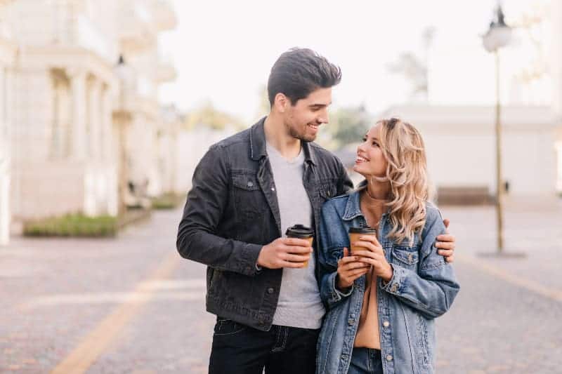 un homme et une femme tenant une tasse de café et se regardant l'un l'autre