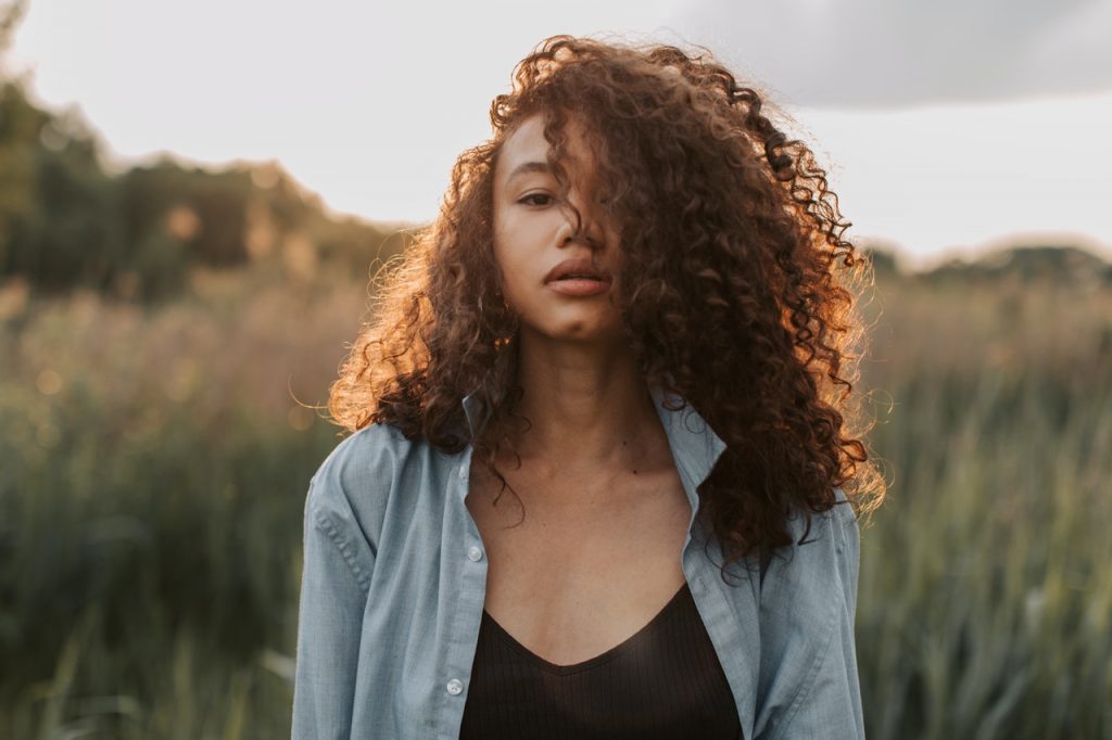 une femme aux cheveux bouclés se dresse