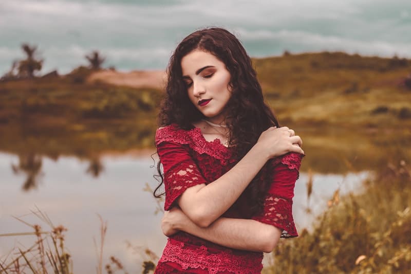 une femme avec un regard abattu se tient près de la rivière