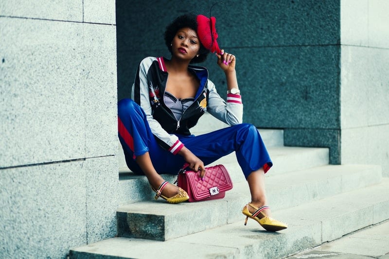 une femme noire avec un chapeau sur la tête est assise sur le dos