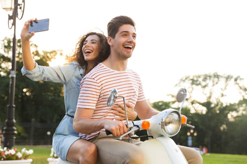 une femme souriante qui prend son selfie tout en se débarrassant de son homme