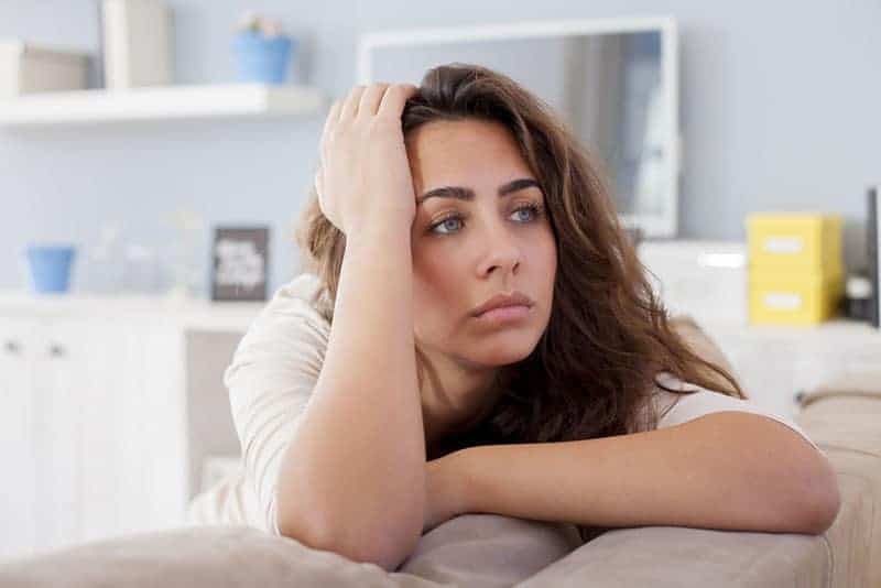 une jeune femme réfléchie qui s'appuie sur sa main à la maison