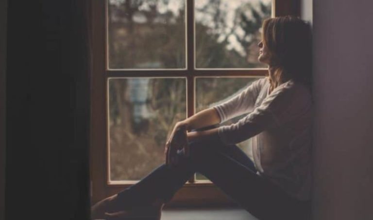 la femme est assise pensivement pres de la fenetre