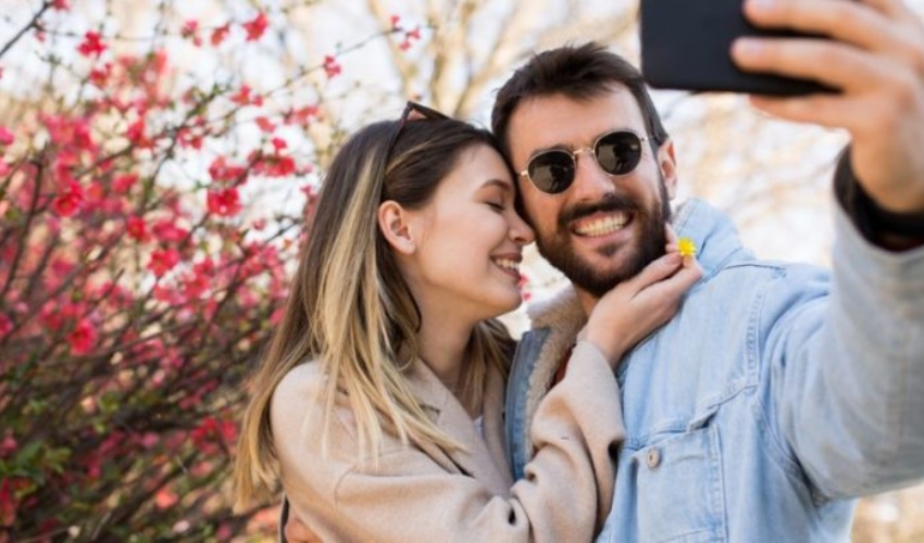 un homme et une femme prennent des photos