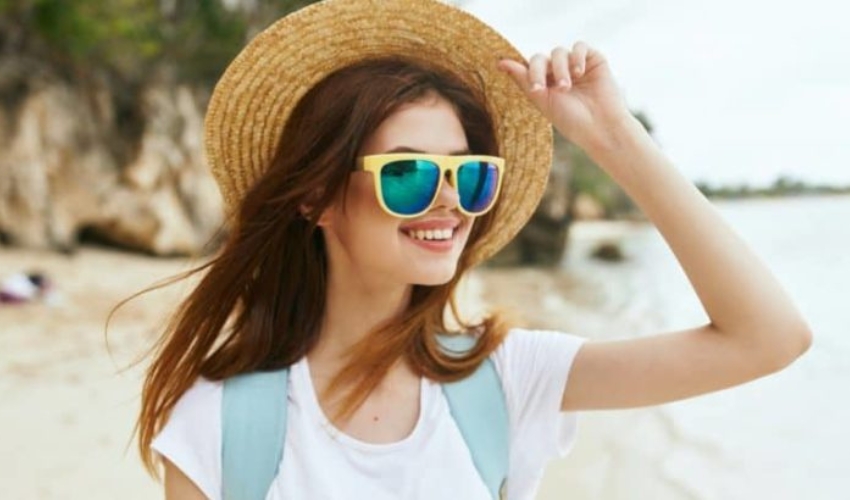 une femme sur la plage avec un chapeau sur la tete