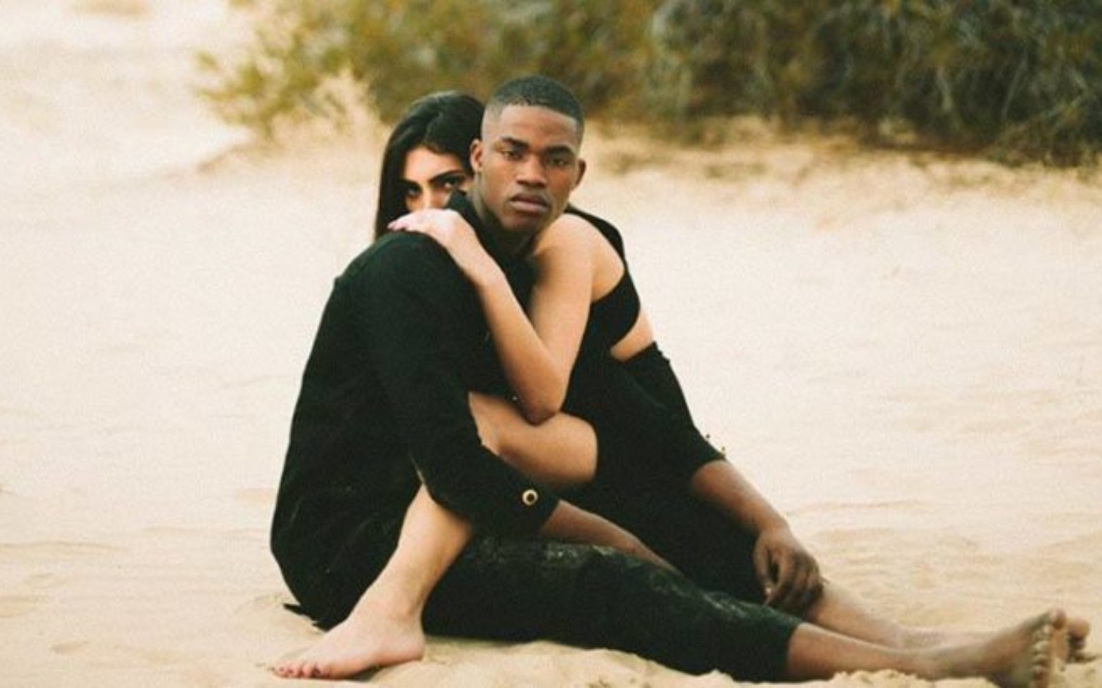 couple assis sur une plage de sable