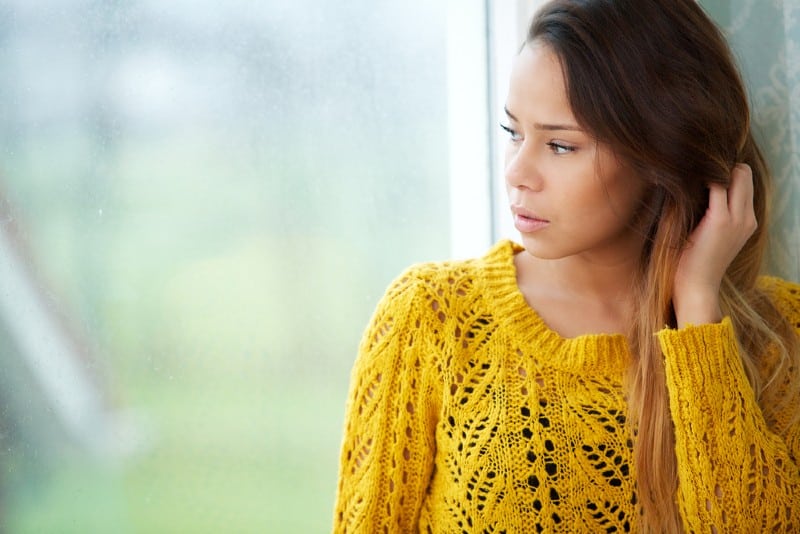 Portrait d'une belle femme regardant par la fenêtre