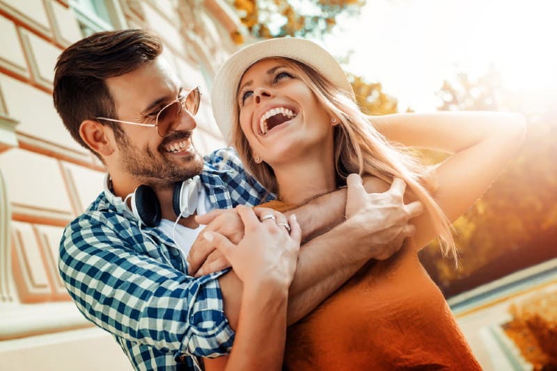 Jeune couple heureux étreignant sur la rue de la ville